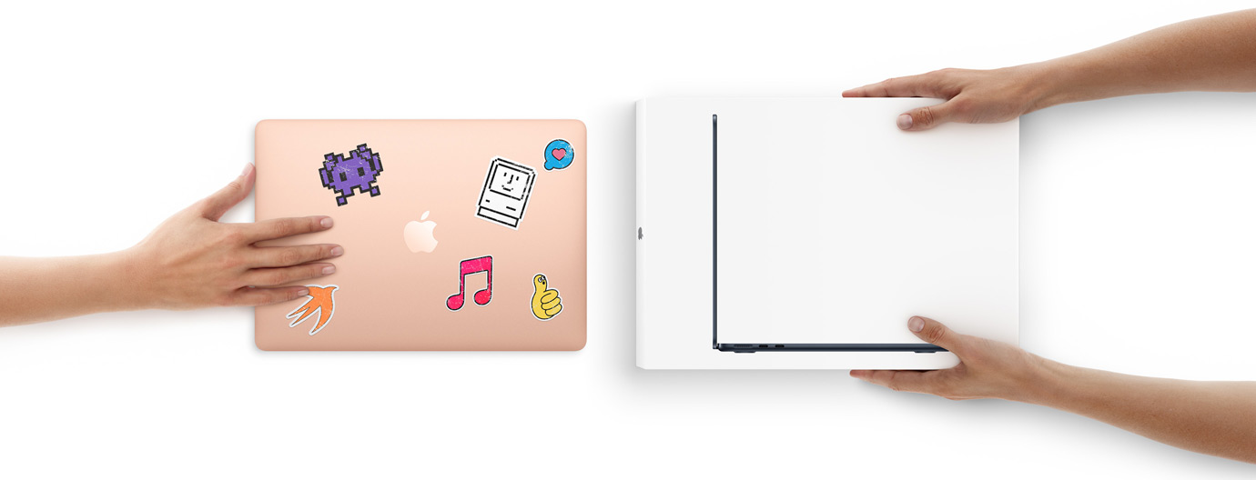Eine Hand schiebt ein MacBook mit Aufklebern auf dem Cover in Richtung zweier Hände, die ein neues MacBook in seiner Verpackung halten