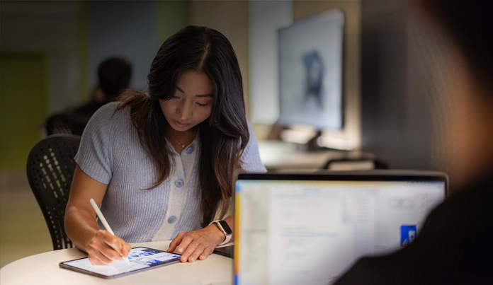 Una estudiante universitaria usa el Apple Pencil para tomar apuntes en un iPad en un laboratorio de tecnología