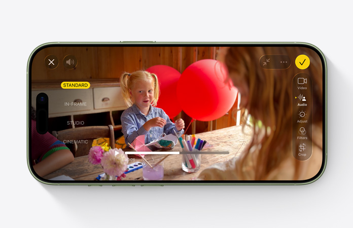iPhone 17, преден екстериор, видео с активиран Audio Mix на дете, играещо с балони на маса