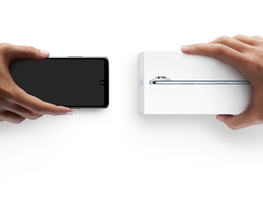 Mains échangeant des téléphones, téléphone Android sans coffret à gauche, nouvel iPhone Air dans son coffret à droite